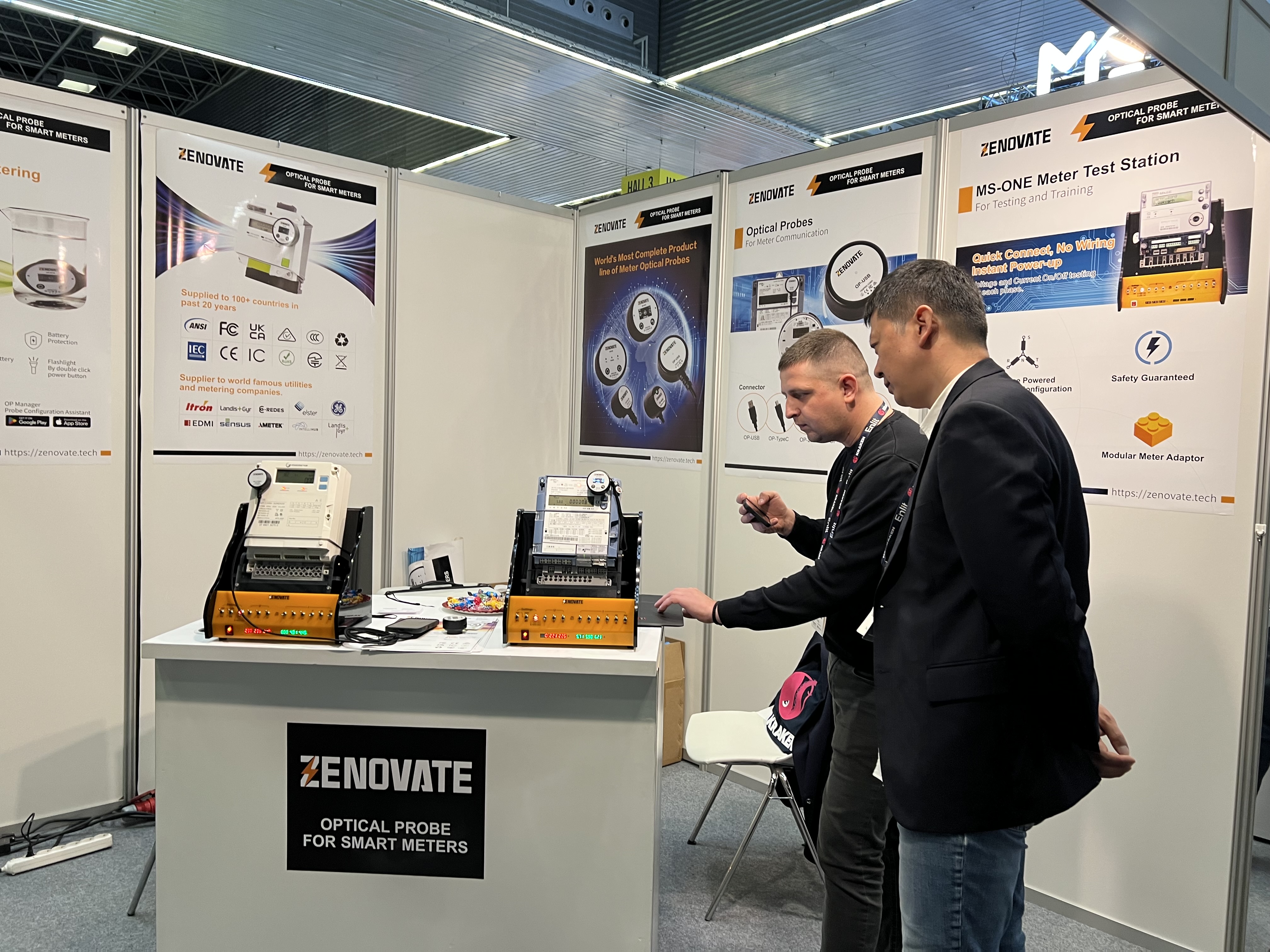 Visitors examining MS-ONE meter test stations during a demonstration at Enlit Europe 2025