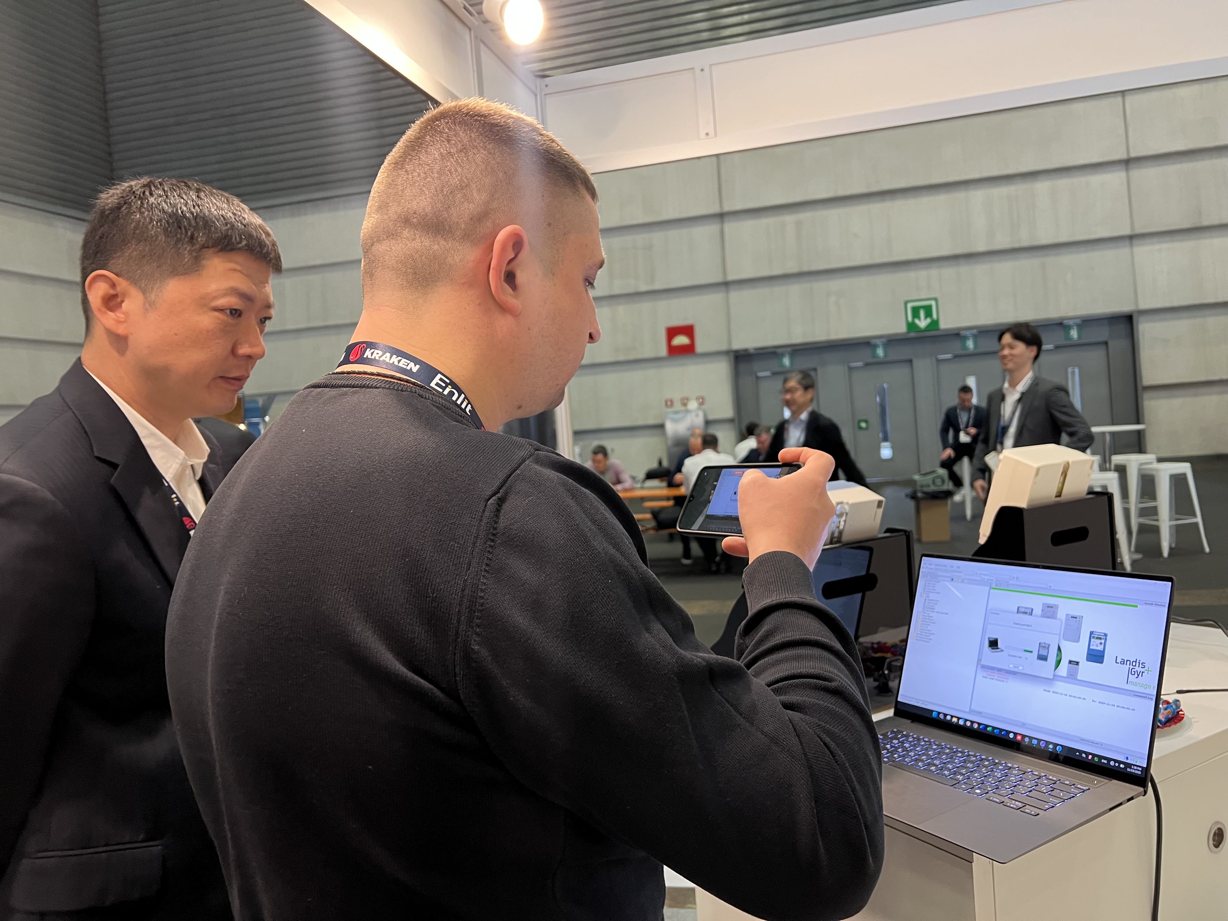 Visitors reviewing a live software demonstration at the Zenovate booth during Enlit Europe 2025